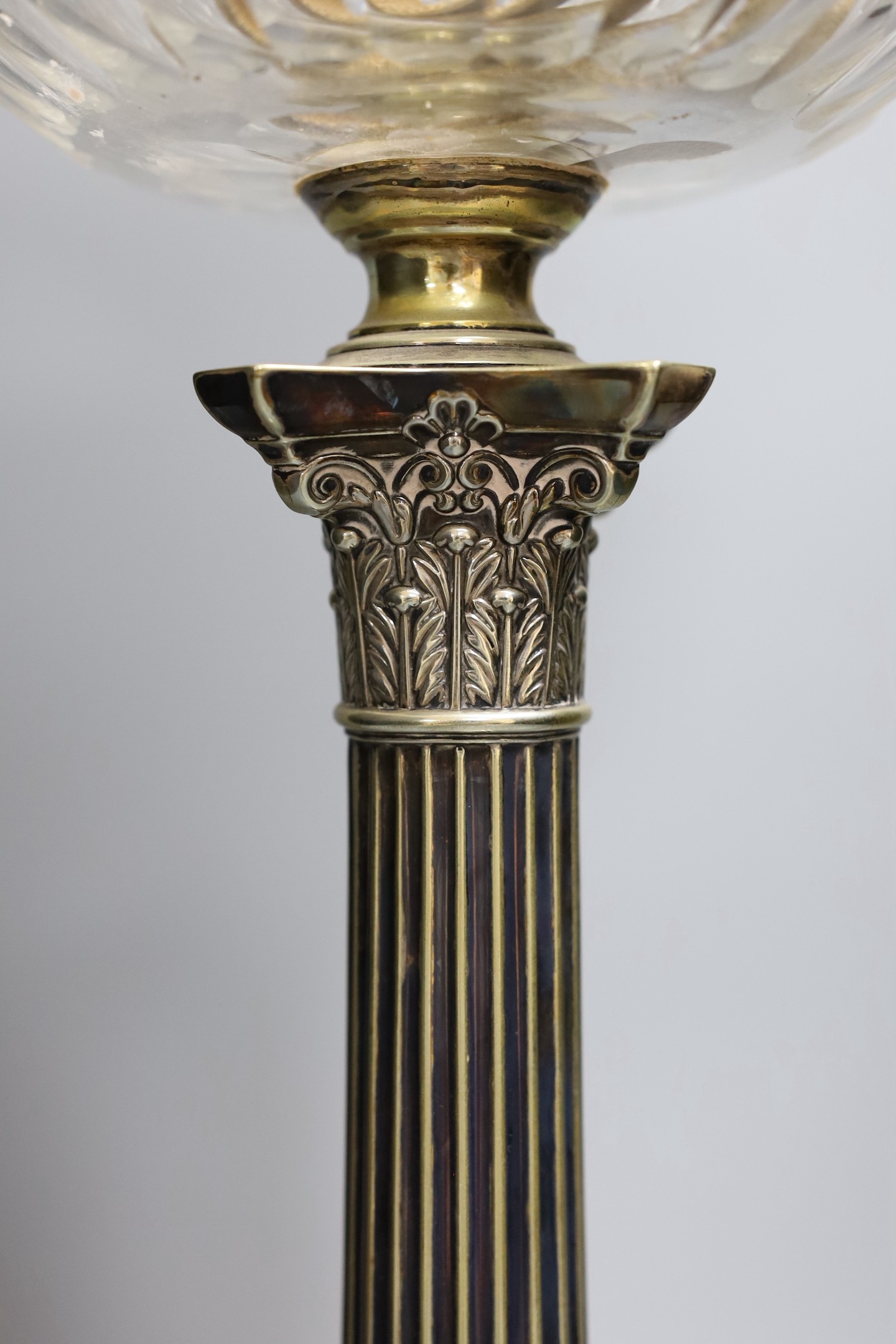 A Victorian silver plated Corinthian column oil lamp, with a glass reservoir